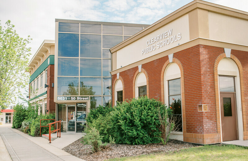 Exterior view of the Clearview Public Schools and Town of Stettler building, located at 5031 – 50 Street, featuring a modern glass entrance and brick façade under a partly cloudy sky.